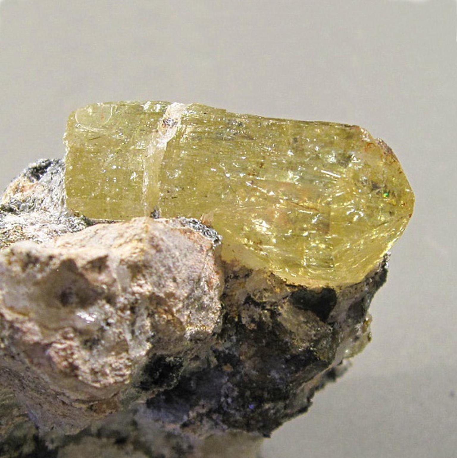 Uncut greenish yellow apatite often referred to as 'the asparagus stone'