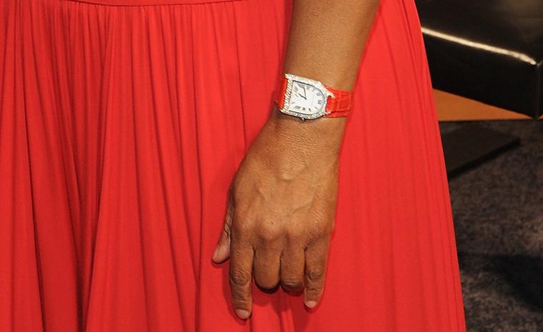 A closer look at the watch on Oprah's wrist reveals a Ralph Lauren Stirrup with diamonds and orange strap to match the dress.