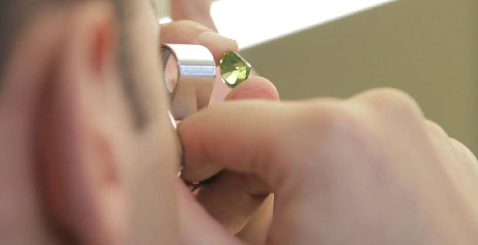 Examining a gemstone through a jewellery loupe at Van Cleef & Arpels L'Ecole