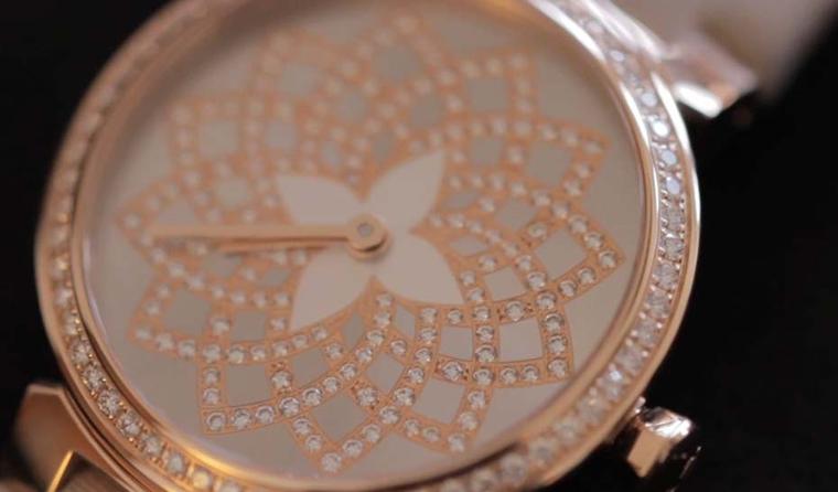 The Louis Vuitton Tambour Monogram Infini features the iconic Louis Vuitton flower logo in mother-of-pearl against the mirror-polished dial.