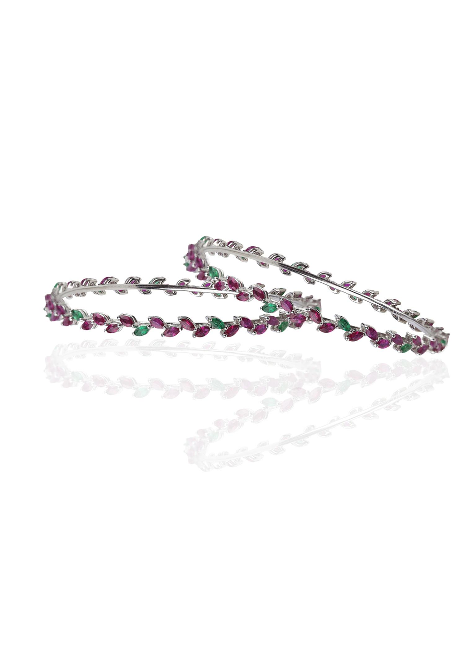 Mirari white gold bangles featuring marquise cut rubies and emeralds.