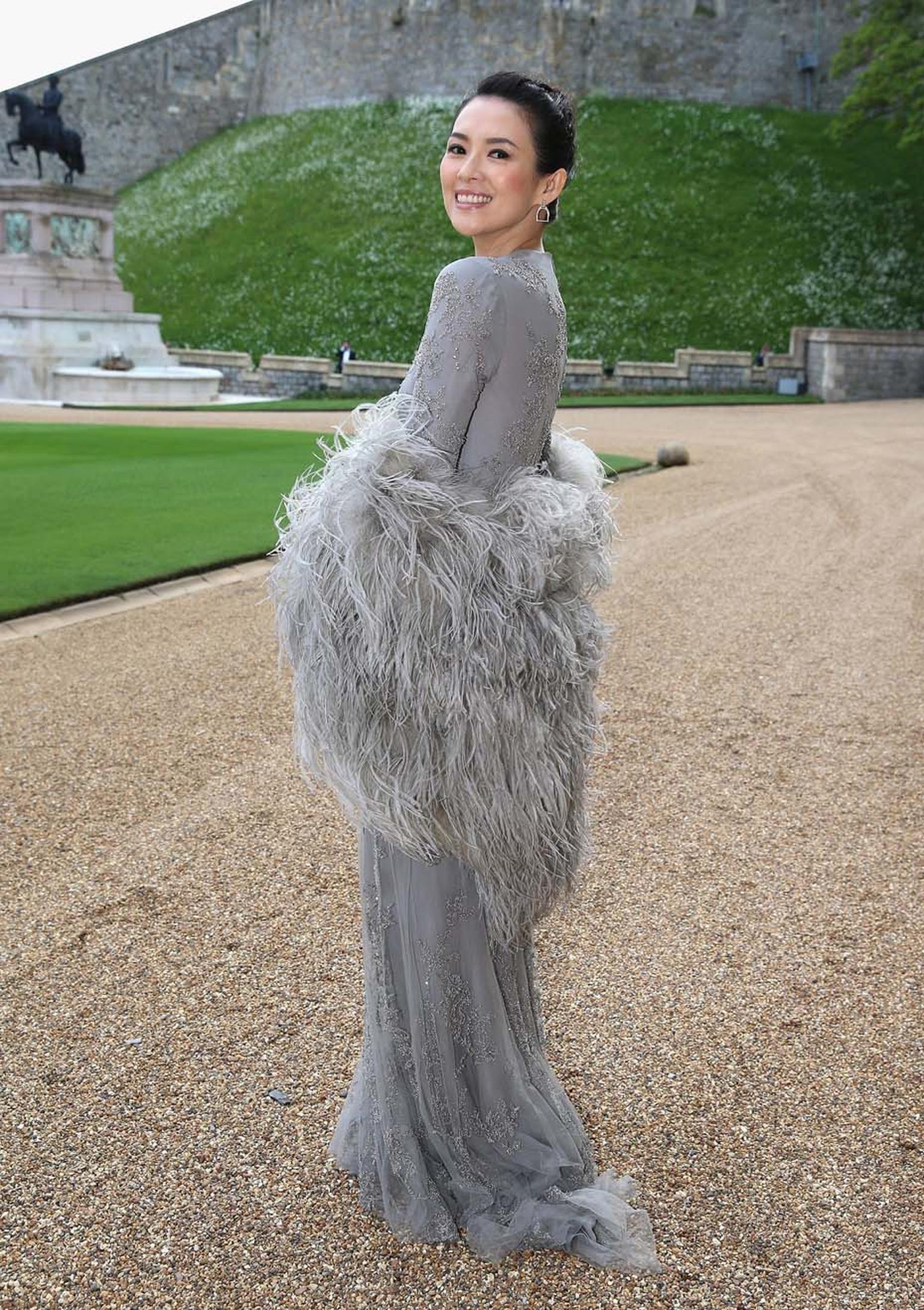Zhang Ziyi in a Ralph Lauren in a grey beaded tulle evening gown, worn with a feather stole, with Ralph Lauren Stirrup earrings pavéd with diamonds.
