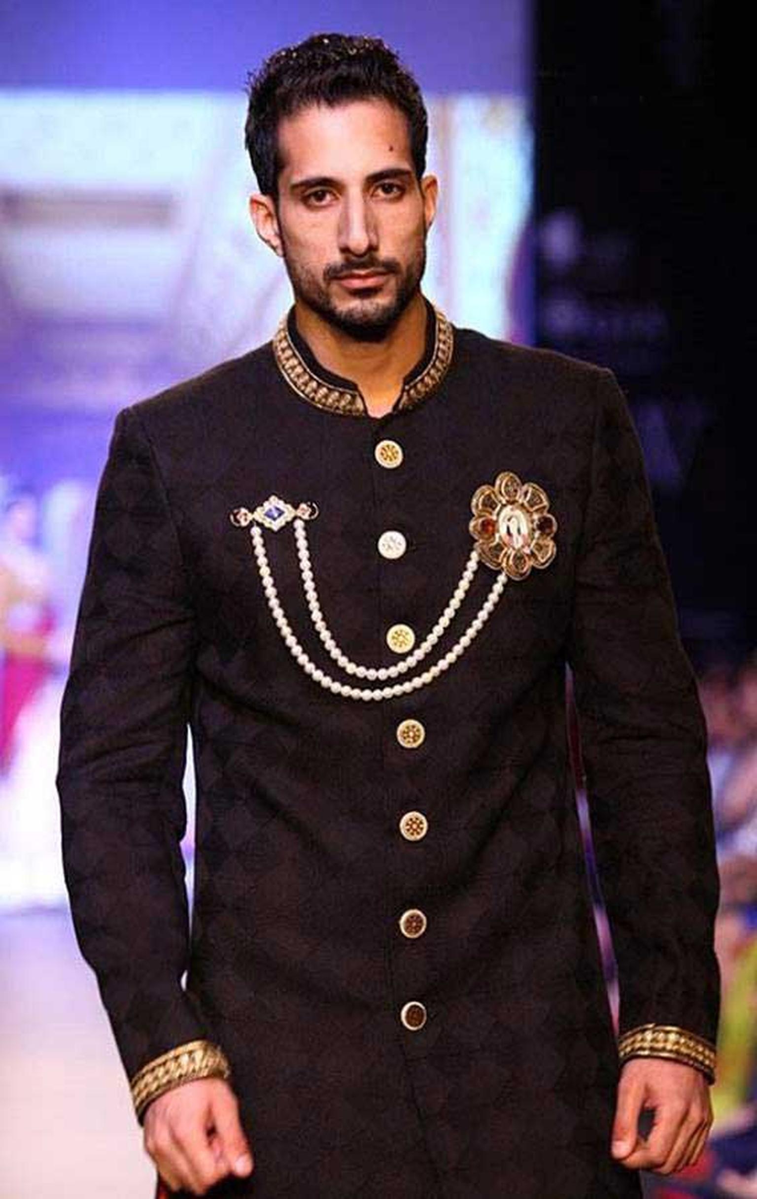 A model at IIJW 2013 wearing Golecha jewels, including jewelled kurta buttons and an elaborate brooch.