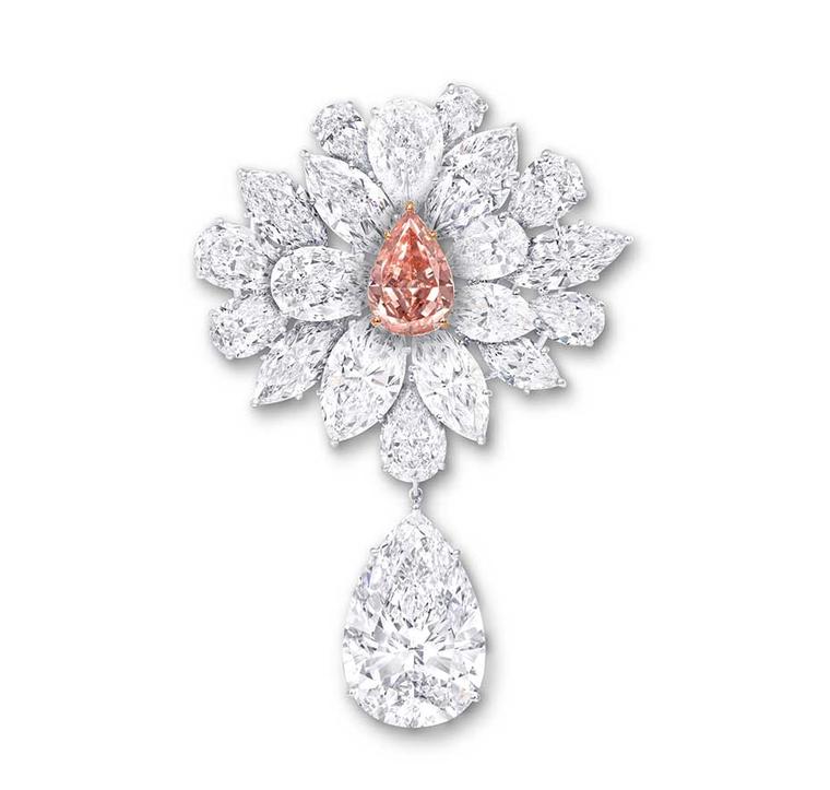 Graff's Diamond Flower Brooch features an 8.97ct pear-shaped Fancy Vivid Pink Orange diamond, surrounded by a spray of white diamond petals and leaves. The brooch is further enhanced with a 38.13ct D Flawless pear-shaped white diamond suspended from a lea