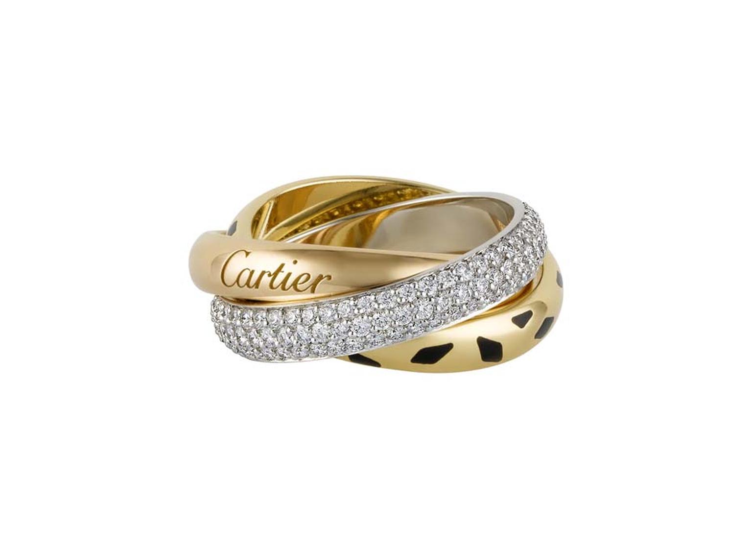 Cartier Trinity Sauvage ring featuring a white gold band pavéd with diamonds, a yellow gold band with black lacquer spots and a pink gold band engraved with Cartier.
