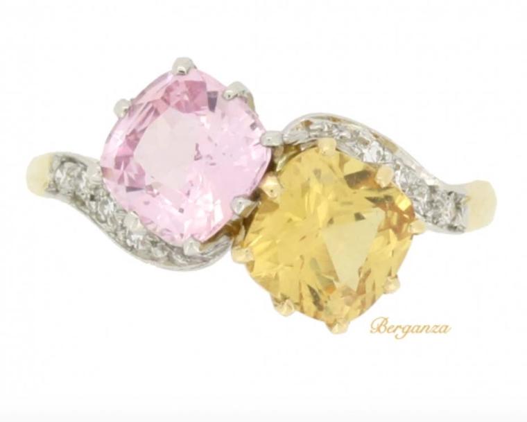 This fancy colour two-stone sapphire crossover Edwardian engagement ring circa 1910 is available at Berganza. Set with an old-cut natural unenhanced yellow Ceylon sapphire and a natural unenhanced peach Ceylon sapphire, both cushion-shaped, the ring is fu
