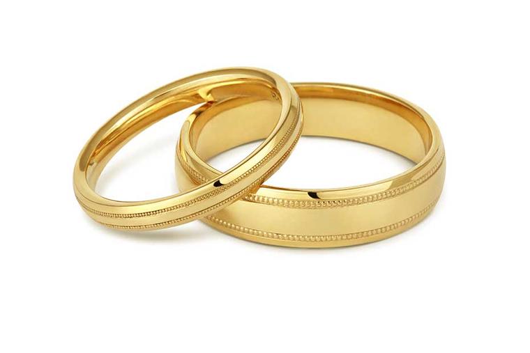 Cred Jewellery's Beaded Edge ethical wedding ring in Fairtrade yellow gold has feather engraving around the band.