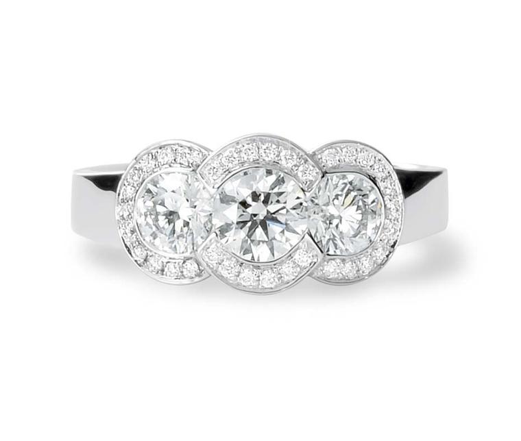 David Robinson's three stone engagement ring is set with three solitaires diamonds in a halo-style surround.