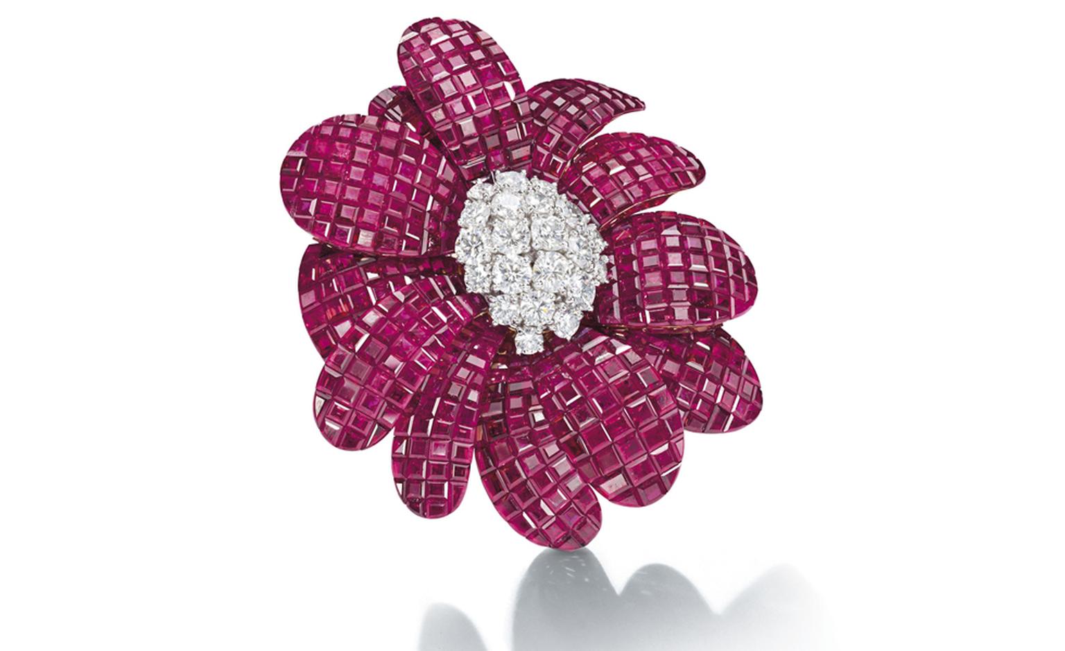 Lot 165. A ruby and diamond 'Cadix' Brooch, br Van Cleef & Arpels.Designed as a flowerhead, the mystery-set ruby petals centering on brilliant-cut diamond pistil mounted en tremblant, mounted in platinum and gold.  Estimate CHF 200,000 - CHF 300,000