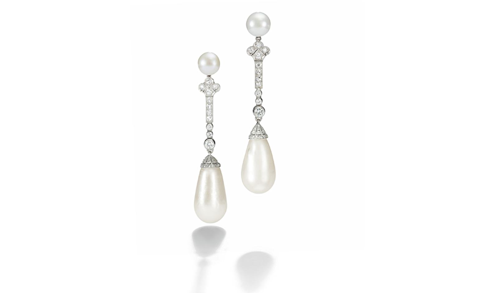 Lot 266, A pair of rare art deco pearl and diamond ear pendants. The two drop-shaped natural pearls, weighing approximately 100 and 96 grains, suspended from a diamond-set line, to the button-shaped pearl tops, circa 1920, 6.6 cm Accompanied by ...