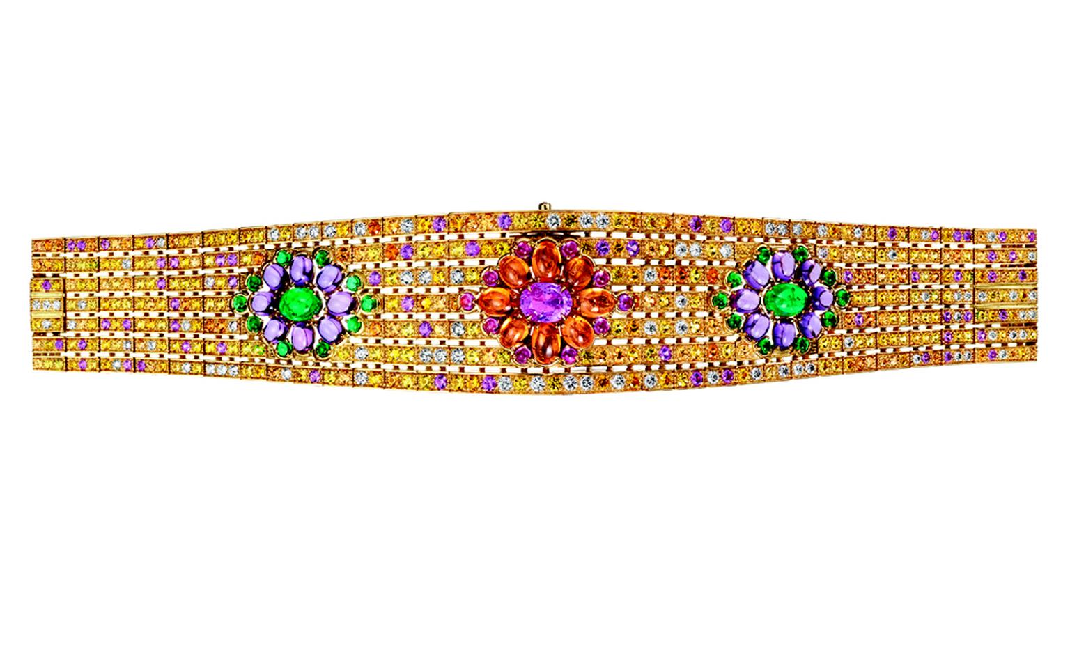 BOUCHERON. Isola Bella watch bracelet, set with a pink oval sapphire and pink and orange cabochon sapphirs, paved with yellow, pink and orange sapphires, emeralds and diamonds, on yellow gold. A watch is hidden under the central pattern. POA