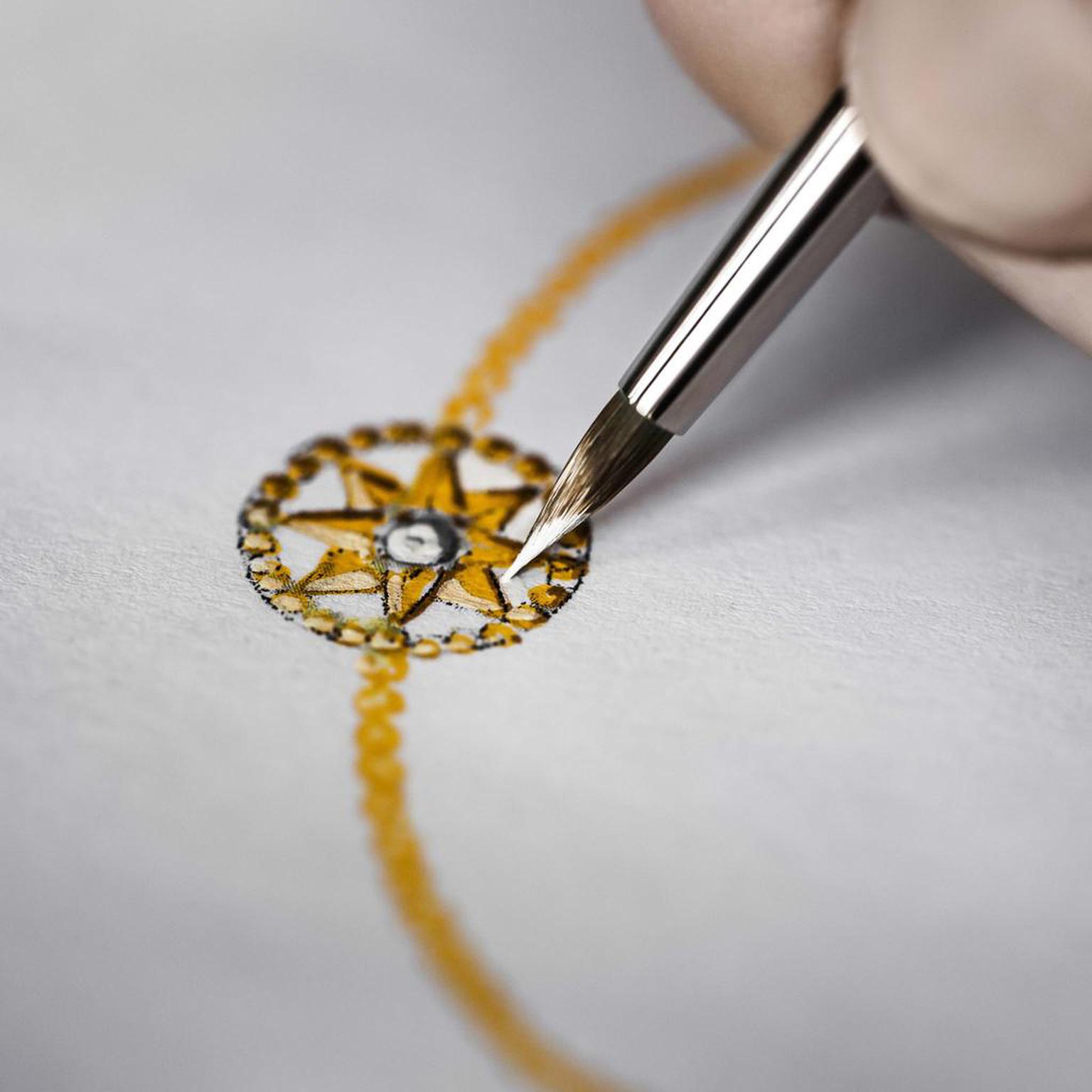 An artist adds fine detail to a gouache of the Rose des Vents bracelet, with its distinctive star motif.