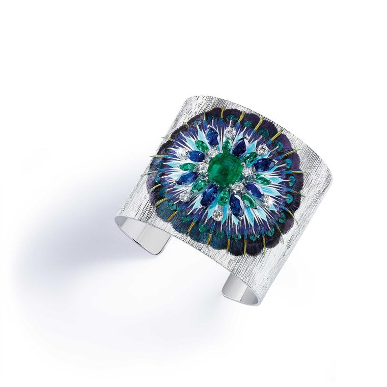 Piaget Serenissima cuff with emeralds, sapphires and diamonds on a bed of feathers