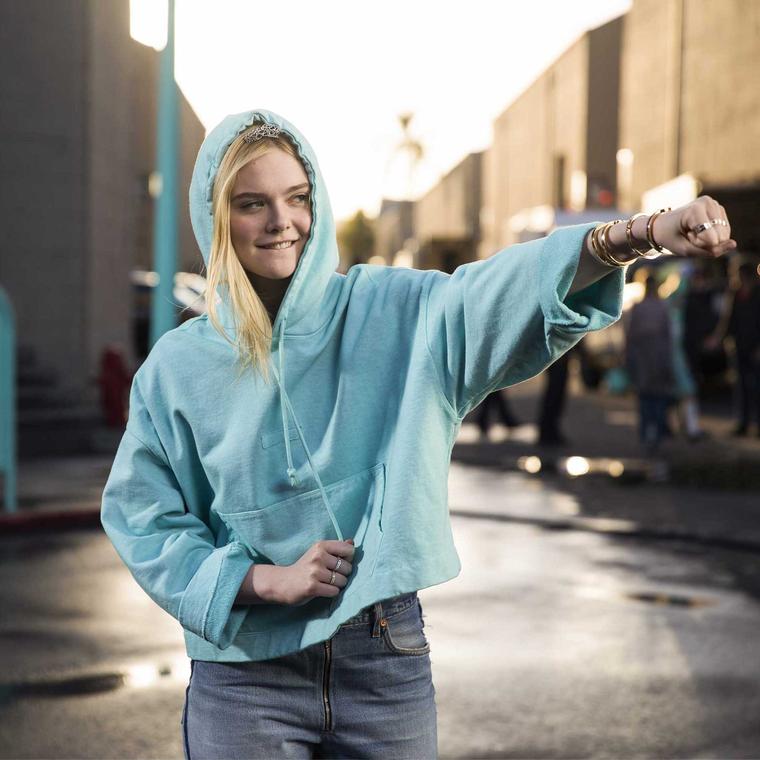 Elle Fanning takes to the streets of New York in a Tiffany blue hoodie, punching some attitude into a new version of Moon River