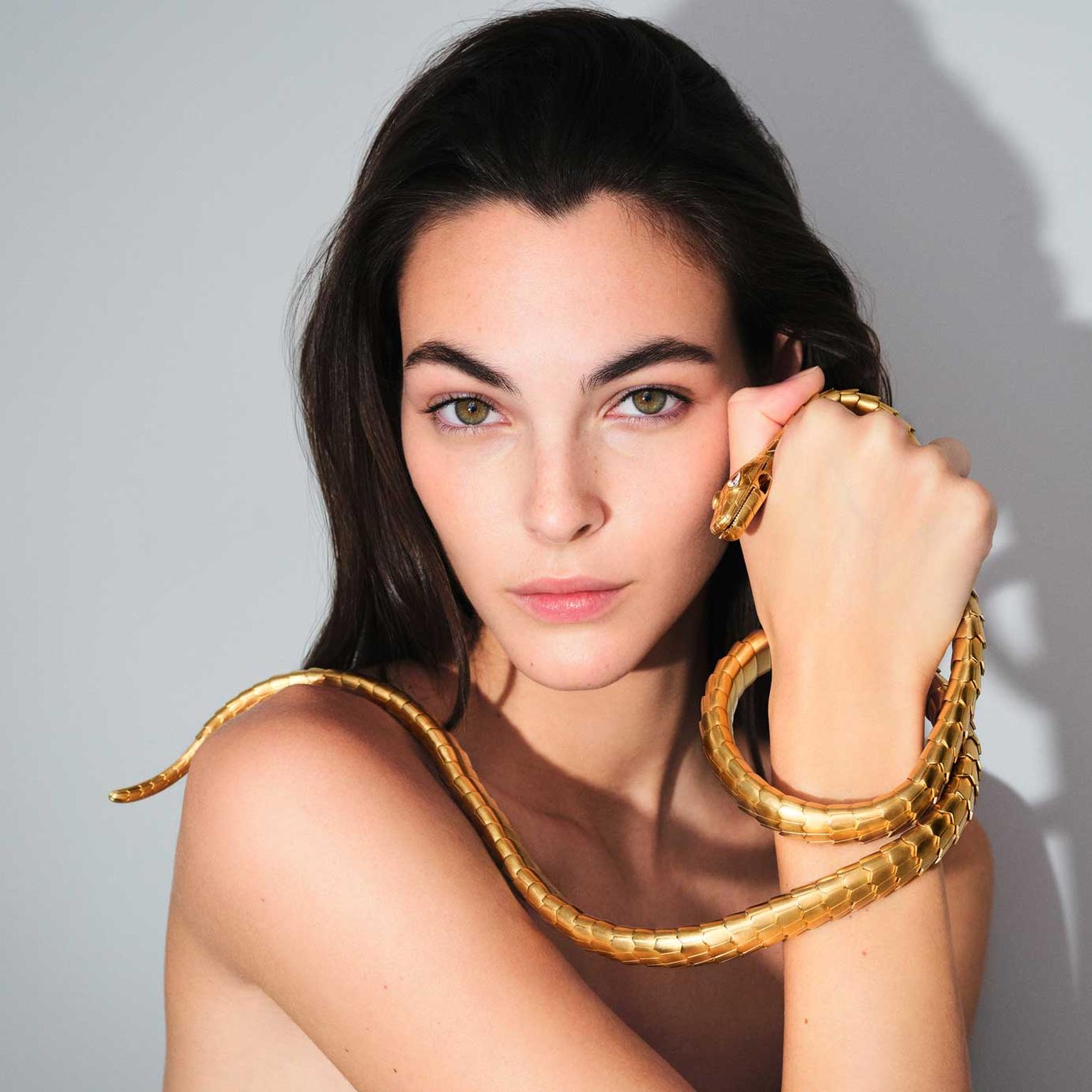 Bulgari Serpenti 75 anniversary model holding gold Serpenti necklace