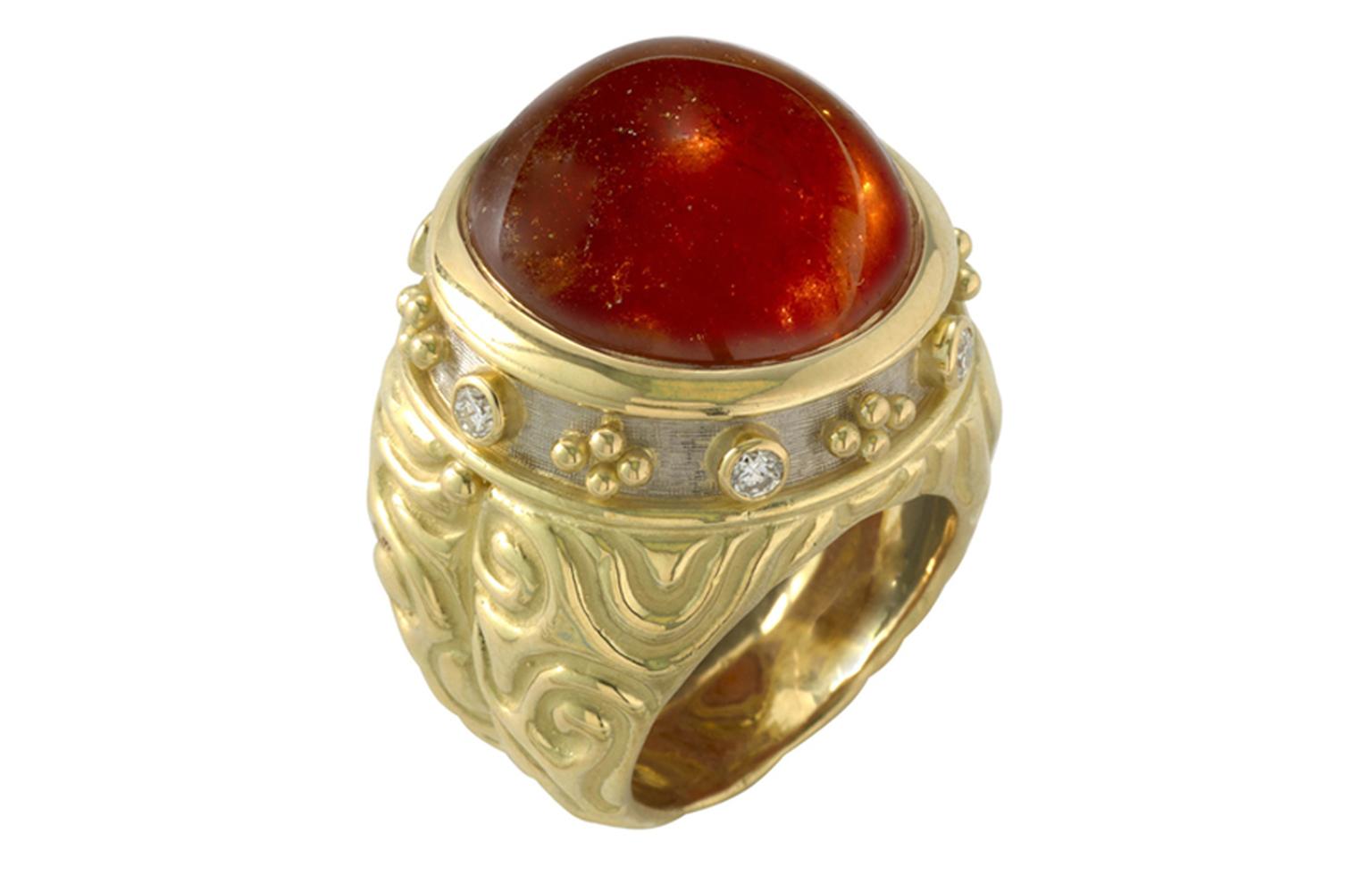 ELIZABETH GAGE, Charlemagne Ring, a glowing round orange cabochon garnet surrounded with diamonds and bead detail in yellow and white gold, with carved molten gold sides. £11,400
