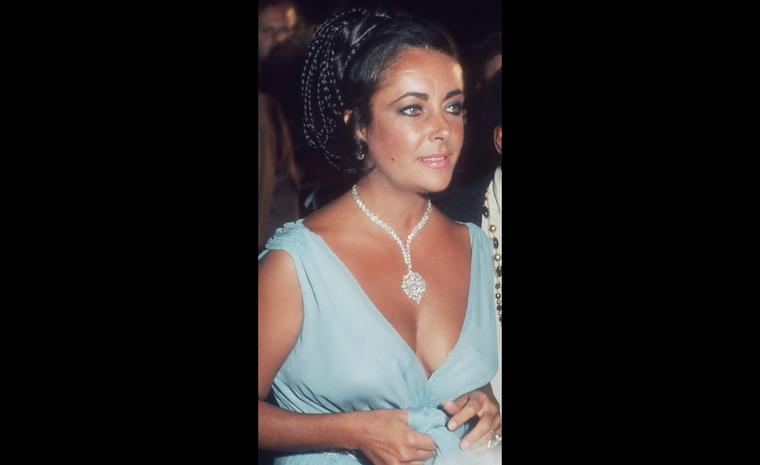 At the 1974 premiere of "That's Entertainment" wearing the Van Cleef & Arpels brooch as a necklace, given to her by Richard Burton and one of the most valuable pieces with a $1,500,000 price tag when he bought it in 1969.