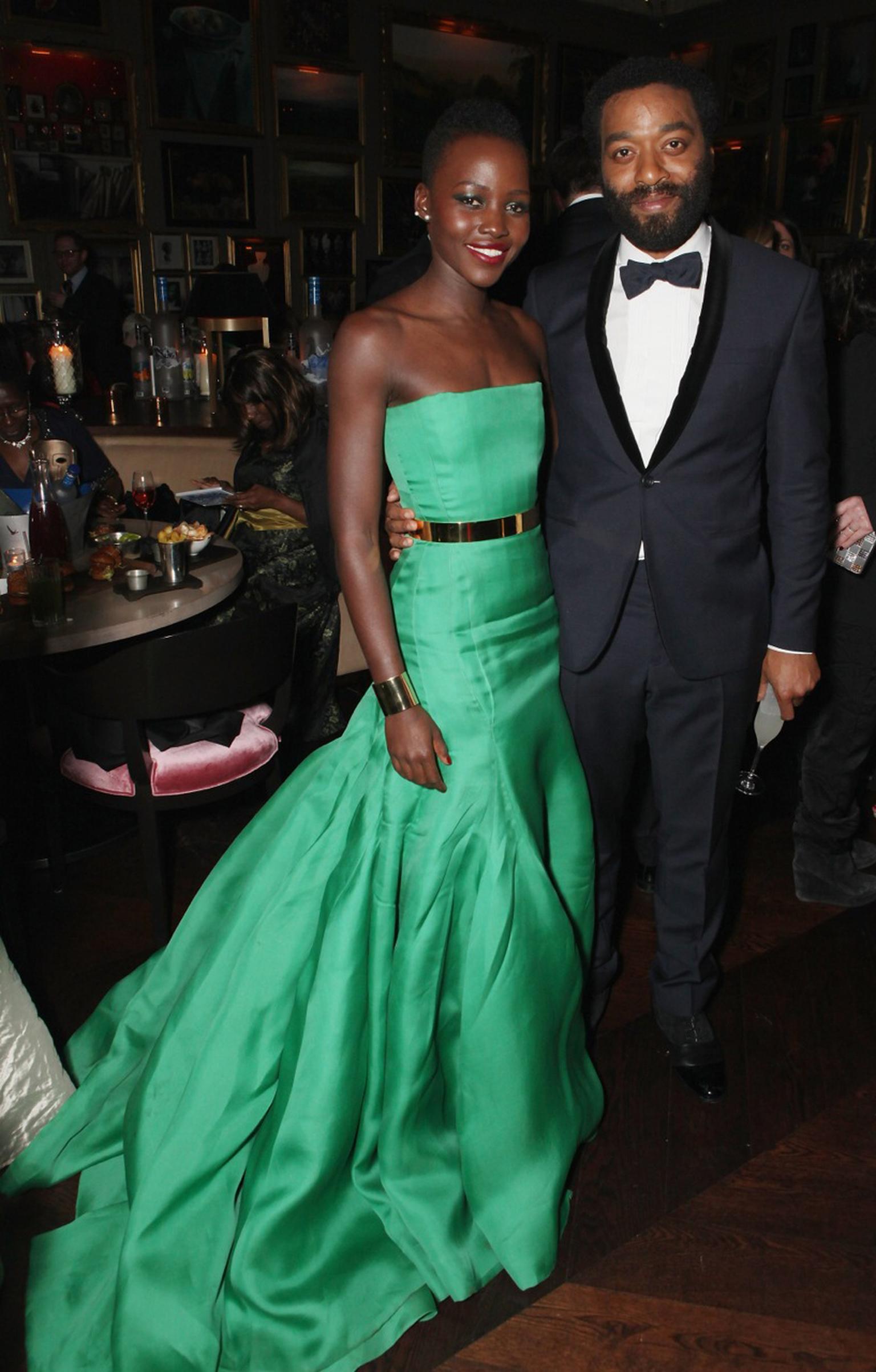 Lupita Nyong'o, BAFTA nominee for her role in '12 Years a Slave', wore an emerald green Dior dress accessorised with two Ana Khouri gold cuff bracelets