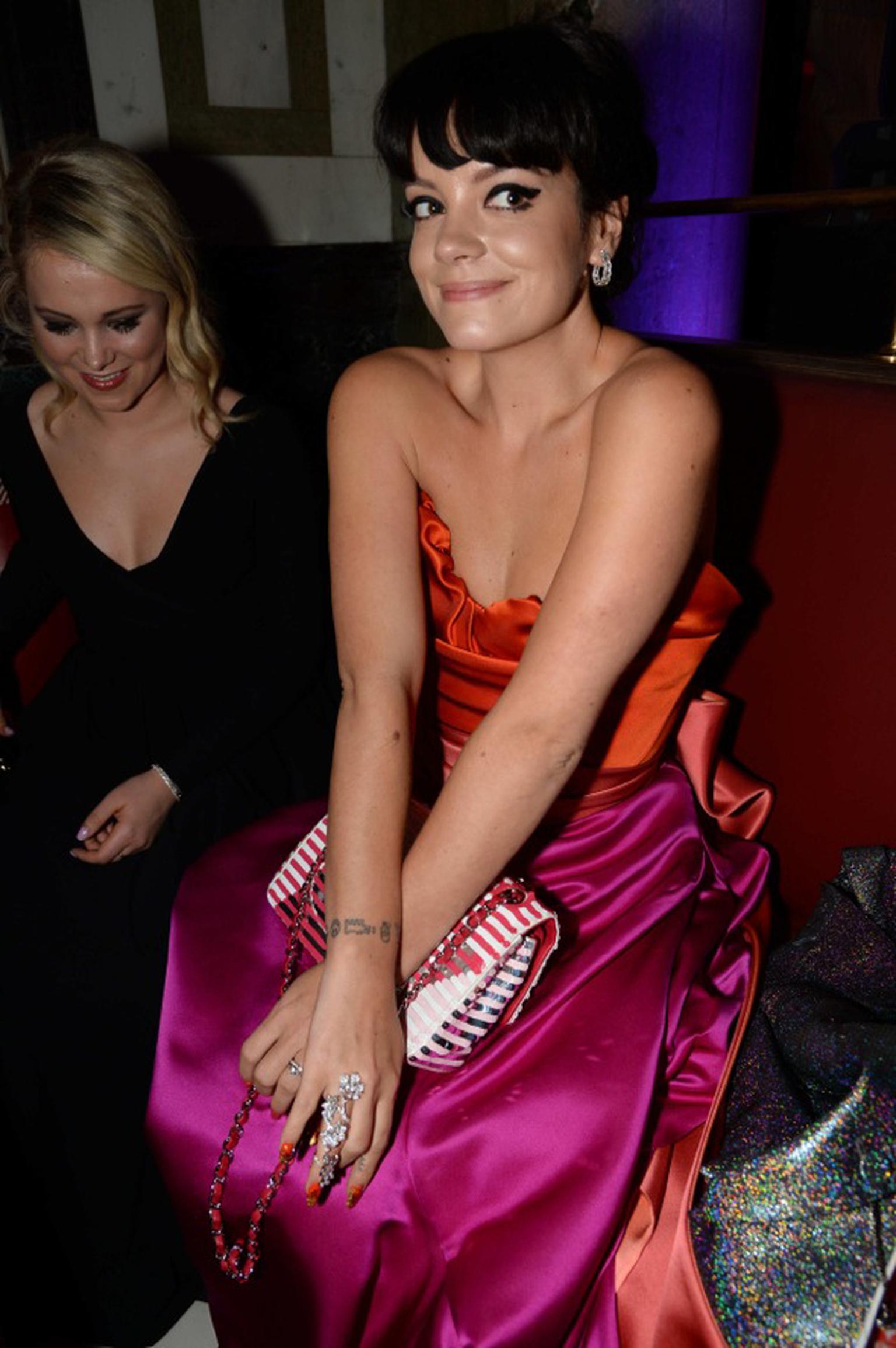 Lily Allen wore a Vivienne Westwood dress and a very cheeky smile to the BAFTAs 2014 as she showed off her David Morris London diamond ring, which ran the entire length of her finger