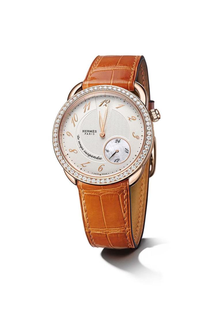 Hermès' Arceau Le temps suspendu 38mm in gold with a gem-set bezel with 62 diamonds. The agate alligator strap is the classic Hermès orange.