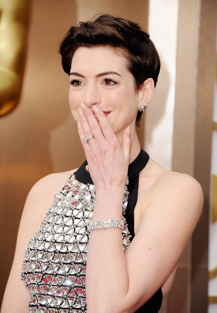 Anne Hathaway on the Oscars red carpet in matching Neil Lane diamond and platinum bracelets valued at US$1 million, a platinum, emerald and diamond ring and platinum and diamond stud earrings, all by Neil Lane