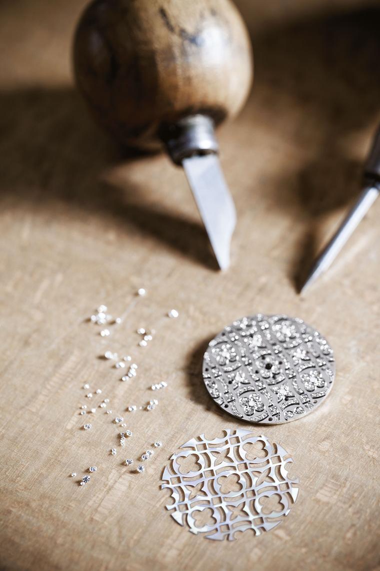 A craftsman at Louis Vuitton's watchmaking atelier setting diamonds on the dial of a Dentelle de Monogram watch