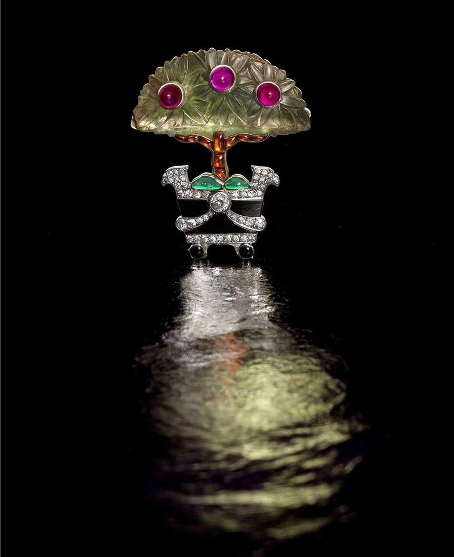 Lot 183, a frosted rock crystal and gem-set Cartier "Orange Tree" brooch dating from 1914, with three cabochon ruby "fruits", a buff-top calibré-cut citrine trunk and cabochon emerald foliage at its base (estimate: £15,000-£20,000)