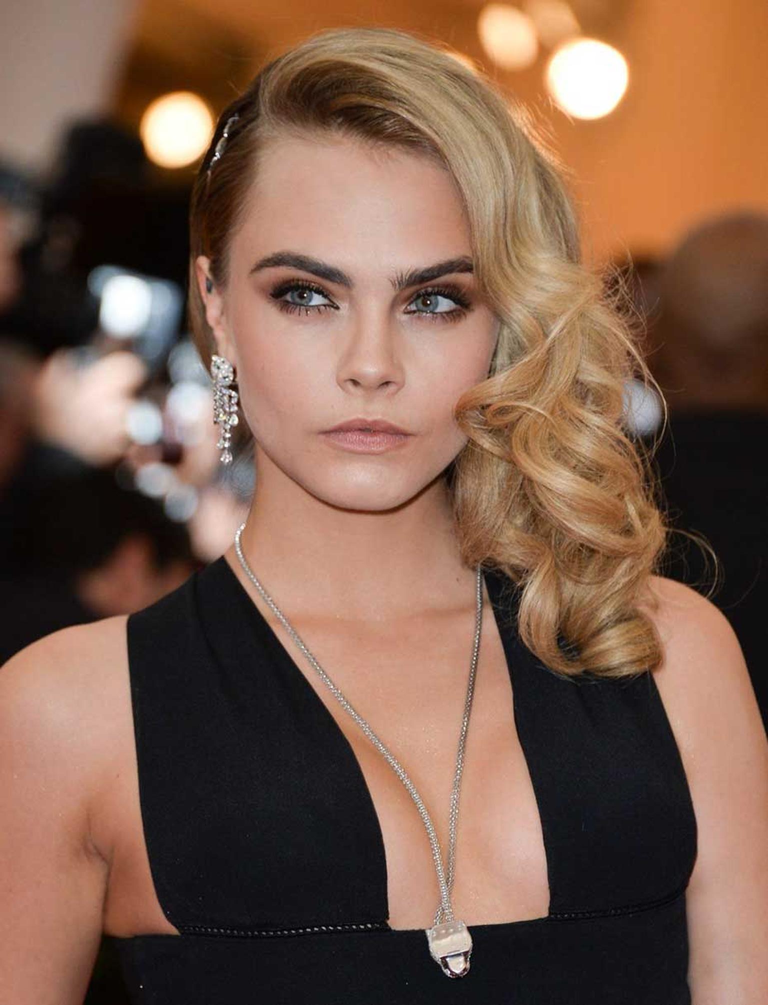 Cara Delevingne wore some of the most impressive jewels of the night, all from Cartier, including a Panthère de Cartier necklace, Panthère earrings and a diamond necklace holding her side-swept hair in place