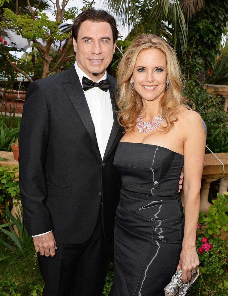 John Travolta looking dapper alongside Kelly Preston, who brightened the seventh day of the Cannes Film Festival in a hot-pink pink sapphire and diamond Avakian necklace and earrings