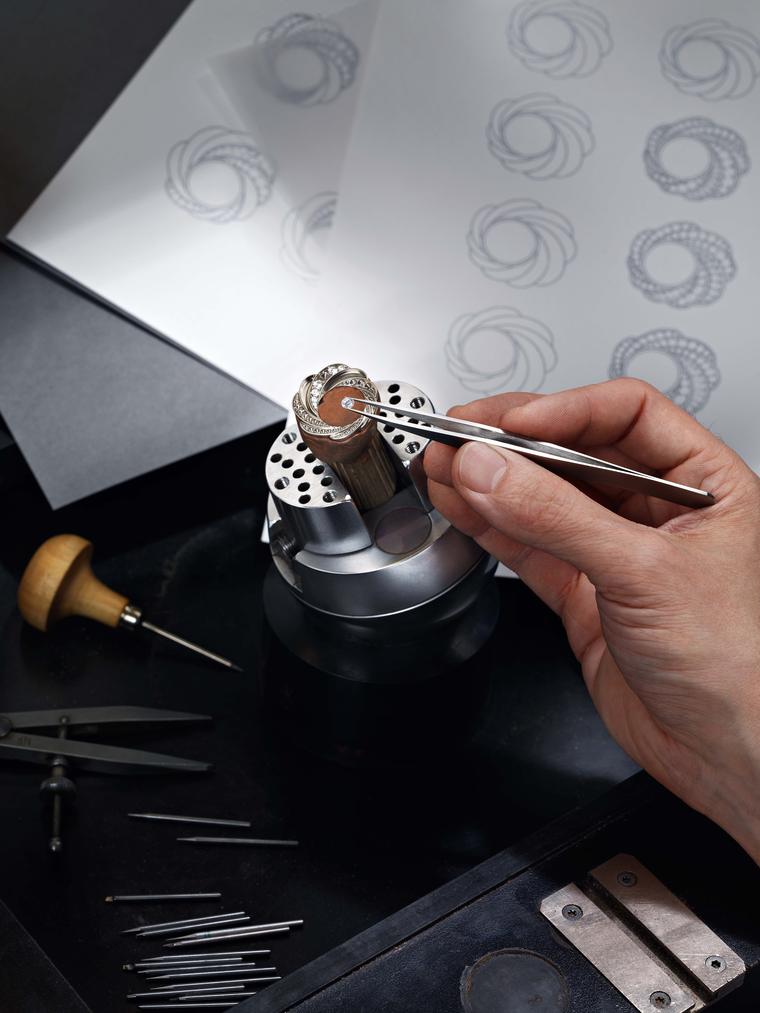 A master craftsman meticulously sets each diamond by hand based on sketches of the swirling Aria design for the new De Beers watches.