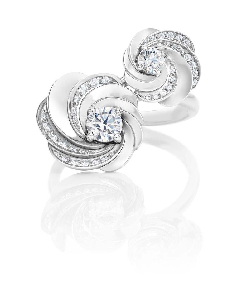De Beers Aria earrings in white gold set with pavé diamonds surrounding a central brilliant-cut diamond.