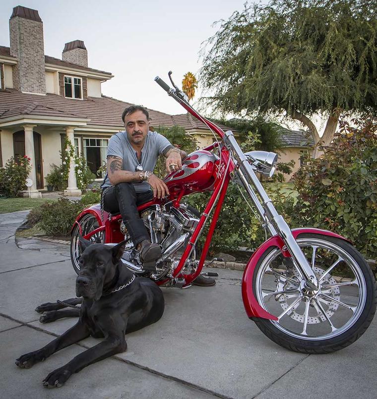 Not your average jewellery designer: Victor Velyan sits astride his motorbike outside his home in LA. The fine jeweller took an unusual career path, starting out as an 80s heavy metal singer and spending 12 years as an African safari guide before settling