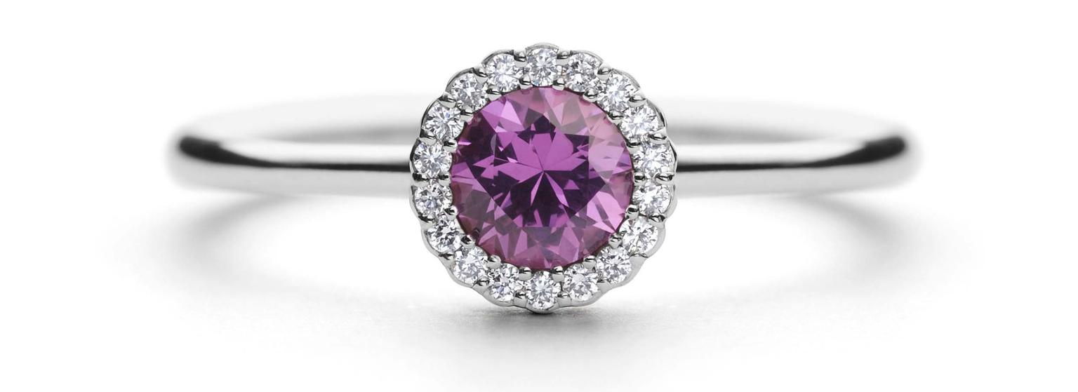 Andrew Geoghegan Cannelé engagement ring in white gold with a brilliant-cut pink sapphire encircled by diamonds.