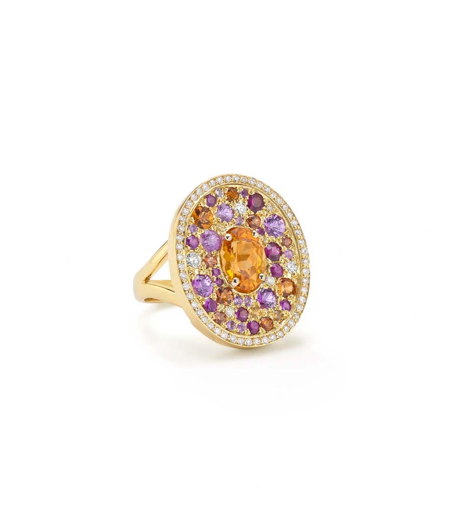 Robinson Pelham white gold Volcano Asteroid ring featuring a central oval mandarin garnet surrounded by a pave of diamonds, rubies and yellow, orange and pink sapphires.