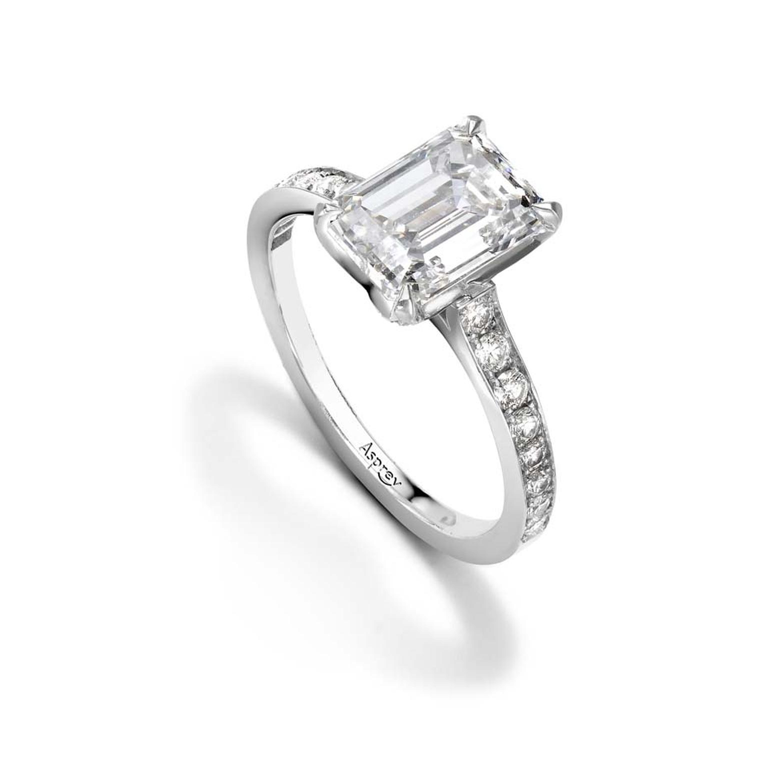 Asprey emerald-cut diamond engagement ring set with round brilliant diamonds on a platinum band.