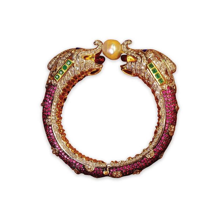 Golecha intricately crafted bangle featuring two elephants holding a pearl, studded with diamonds, rubies and emeralds.