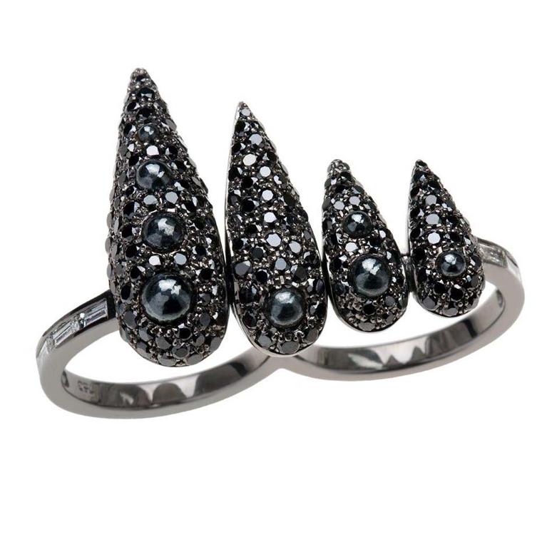 Nikos Koulis black diamond and rhodium ring featuring cascading proportions offset by the white diamond baguettes on its shoulders.