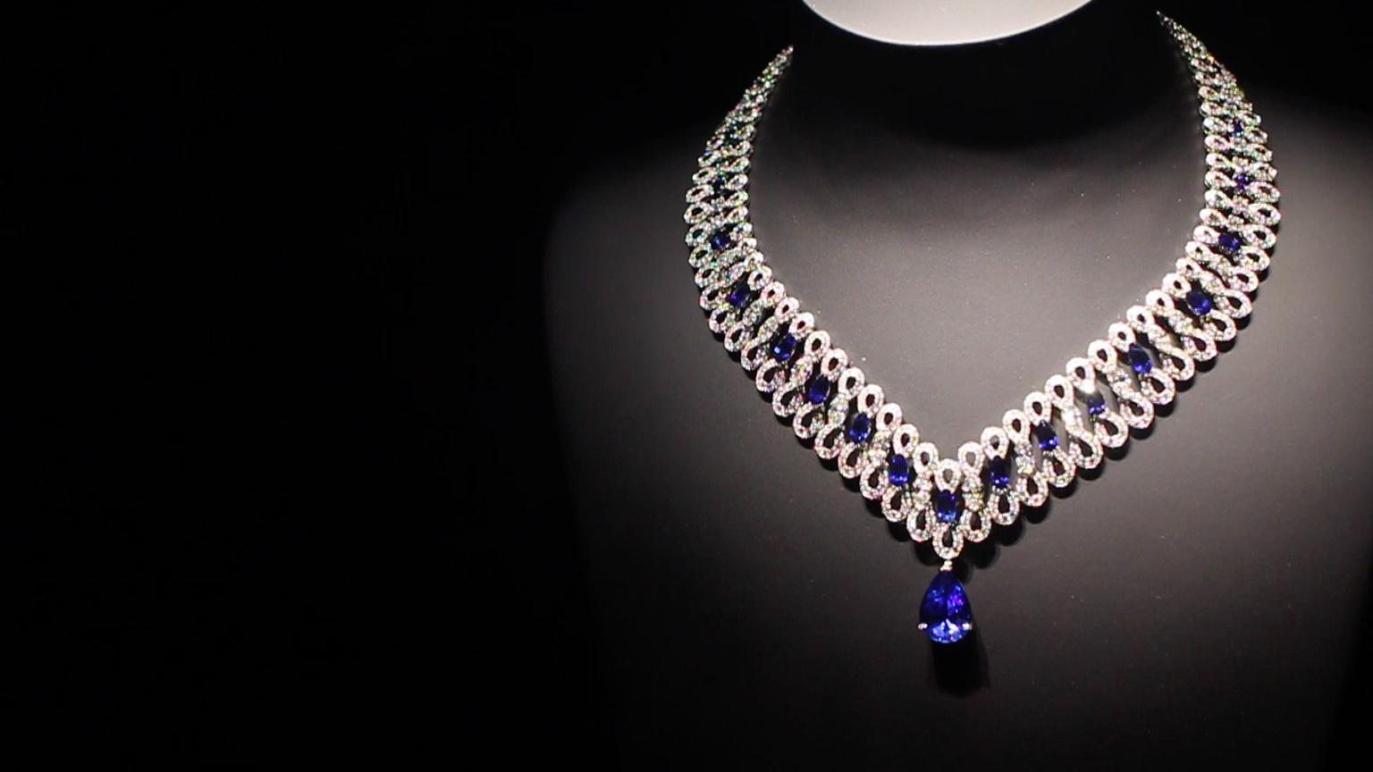 Extremely Piaget collection Infinity necklace with diamonds intertwining like ribbon underneath pear-shaped sapphires and diamonds leading to a dangling sapphire pear-shaped drop.