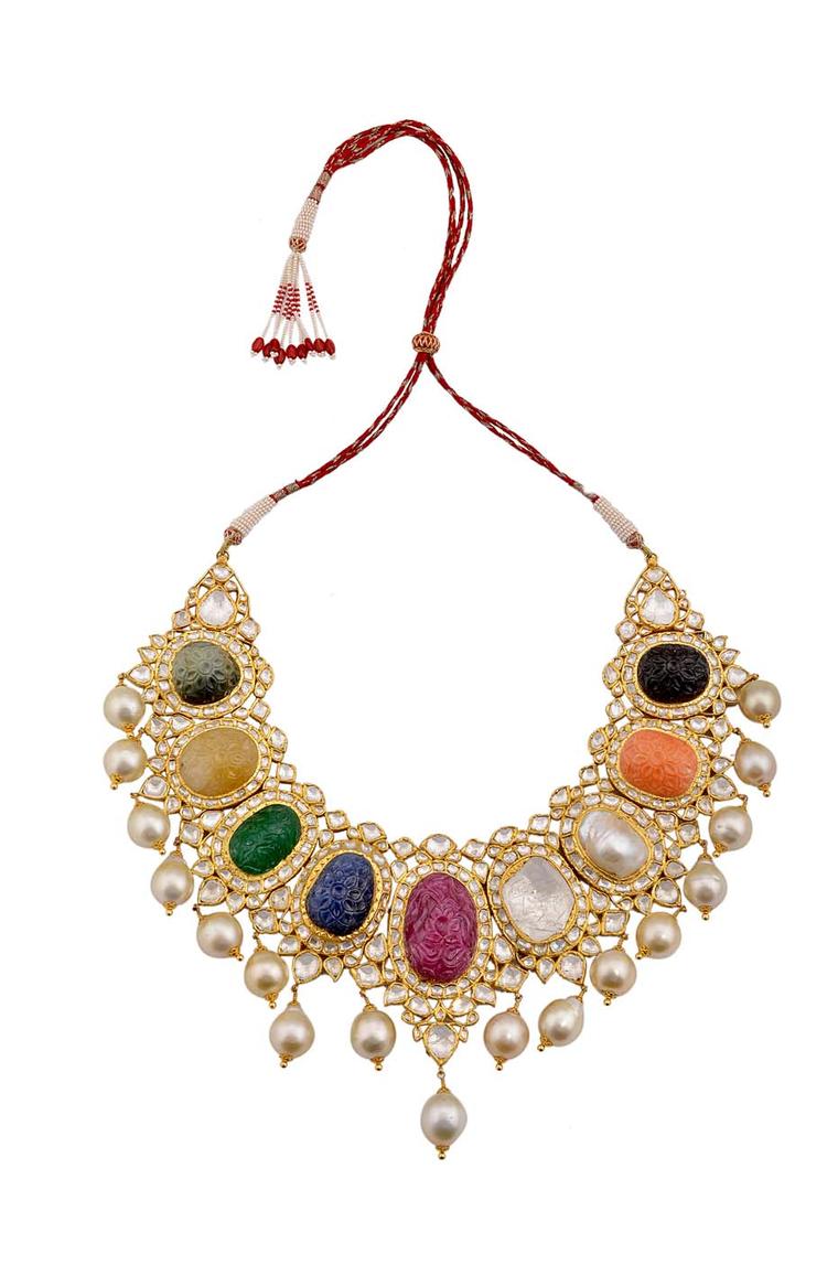 Amrapali’s traditional Navratna (nine gem) necklace featuring eight carved gemstones and one large uncut diamond surrounded by diamonds and pearl drops.