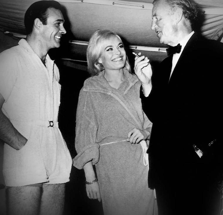 Ian Fleming chatting with Sean Connery and Honor Blackman on the set of Goldfinger. Fleming was a die-hard Rolex fan, with his watch of choice being the Rolex Oyster Explorer.