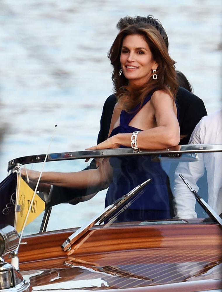 Cindy Crawford makes her way to the wedding of George Clooney and Amal Alamuddin by speedboat wearing Harry Winston Diamond Links bracelet and earrings.