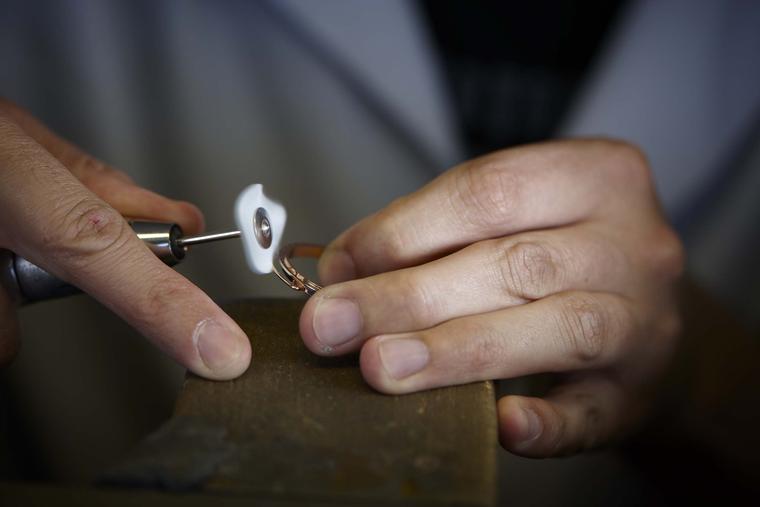 The exterior bezel is polished prior to the setting of the orange briolette-cut sapphires.