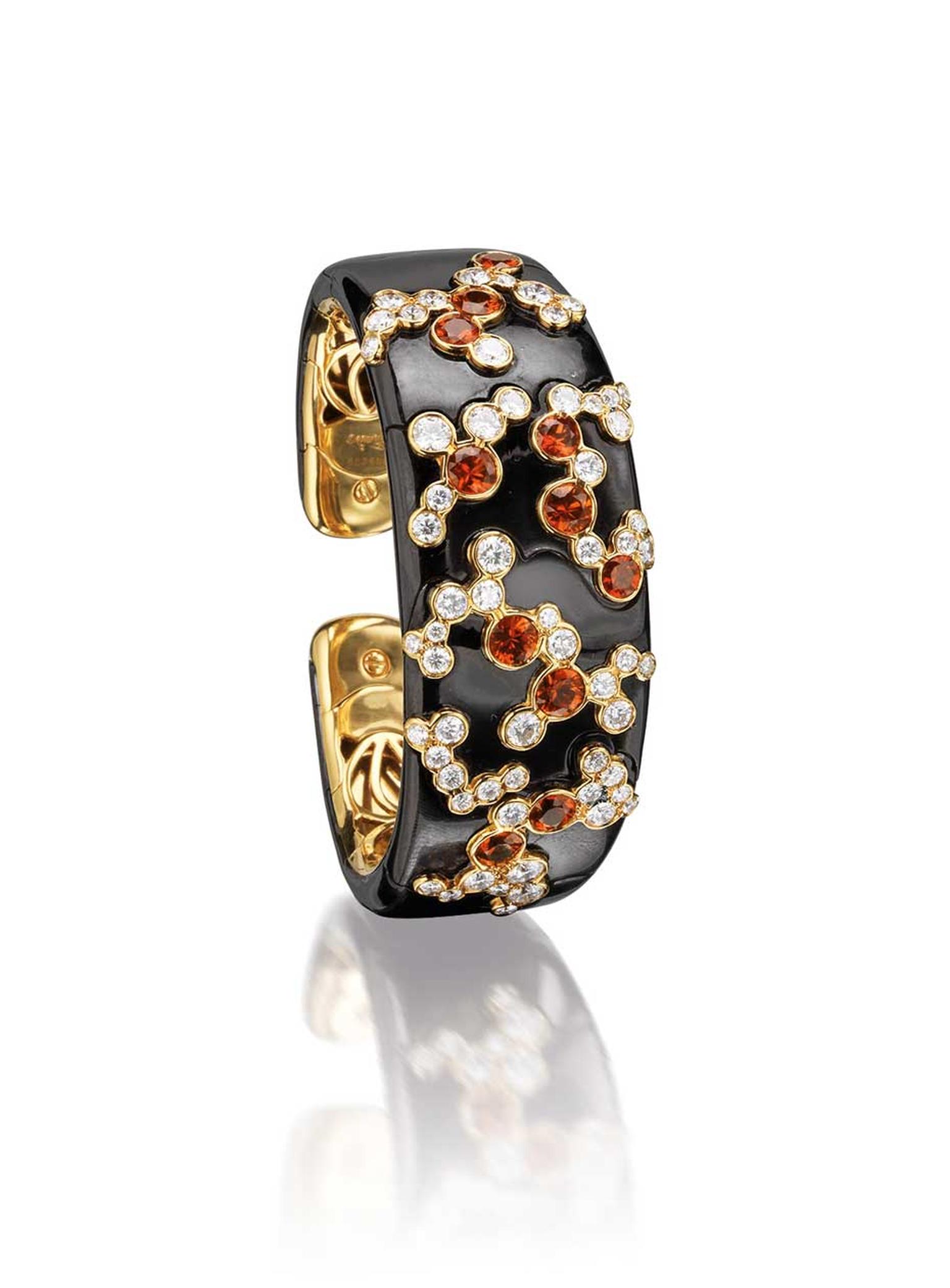 Marina B hinged bangle, influenced by Japanese culture and the cherry blossom. The bangle features brilliant-cut diamonds and circular-cut orange sapphires (estimate: £10,900-15,600).