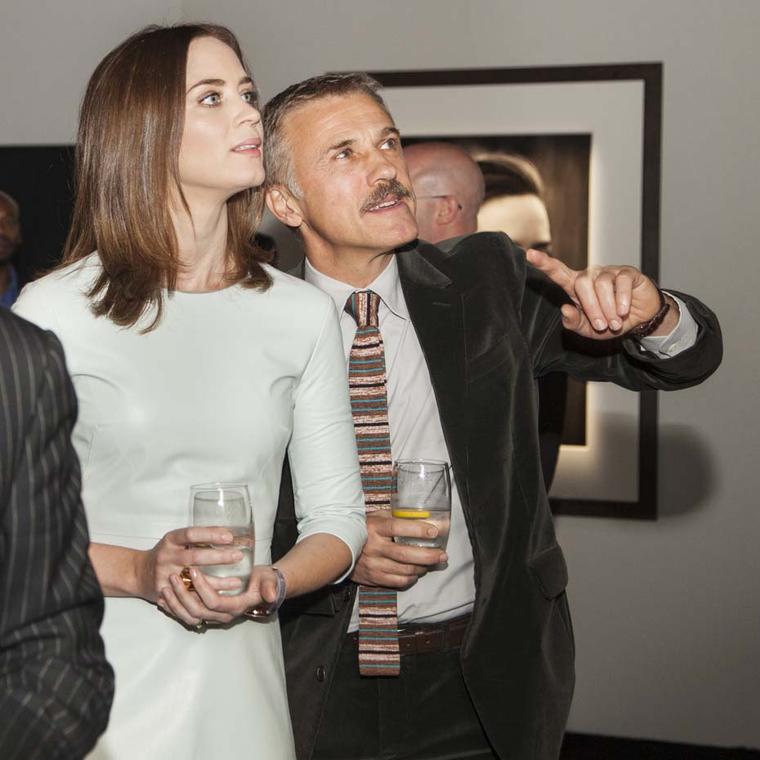 Emily Blunt and Christoph Waltz discuss one of Peter Lindbergh's photographs in the ''Timeless Portofino'' exhibition. Image by: PHOTOPRESS/IWC