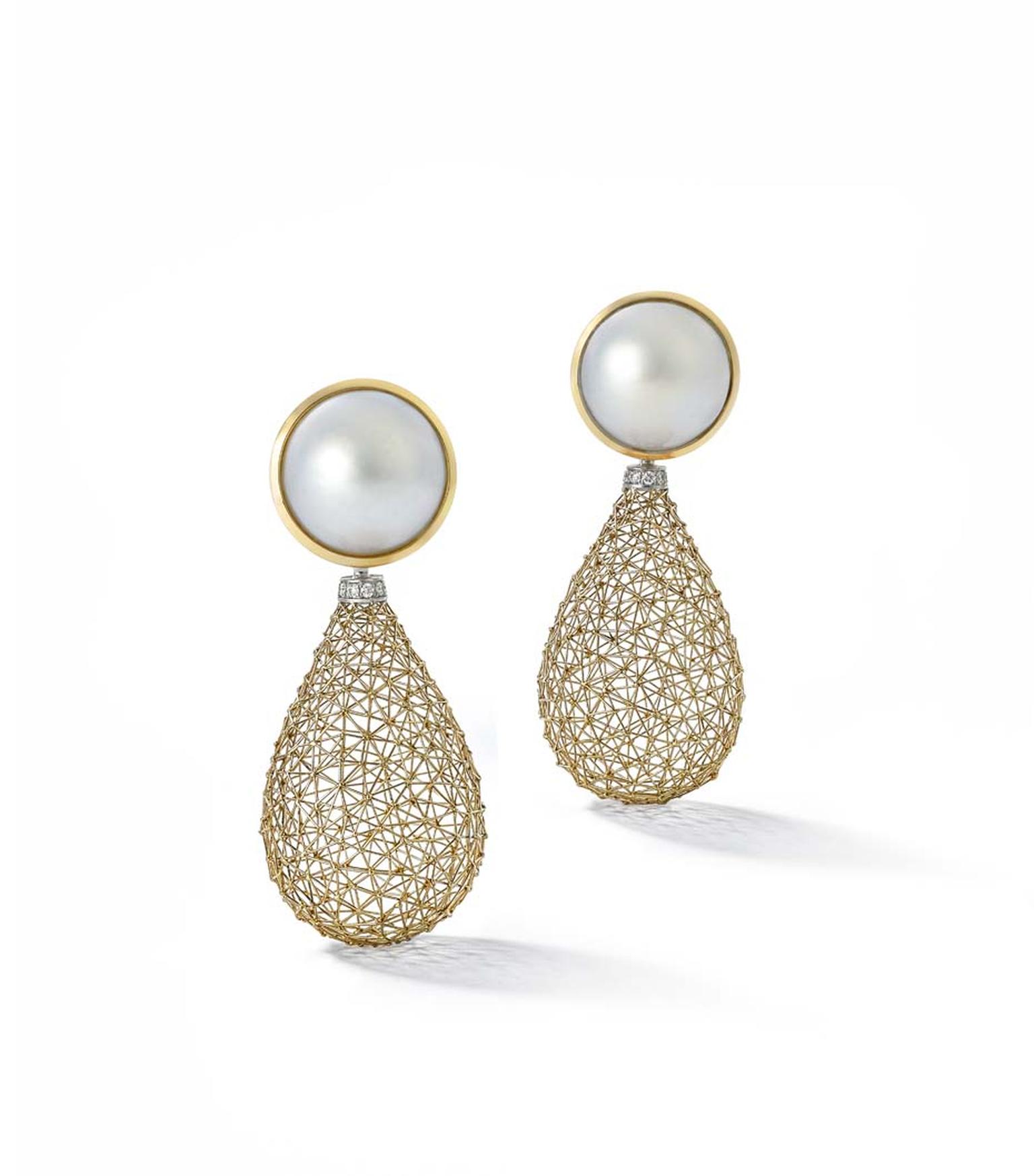 Tom Rucker Geosphere Gemini ear pendants featuring white gold drops with a lattice work design and diamond-set cusps, suspended from a mabe pearl.