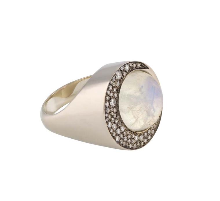 Noor Fares Eclipse ring with a blue moonstone centre set in grey gold surrounded by a crescent of white diamonds in black rhodium.