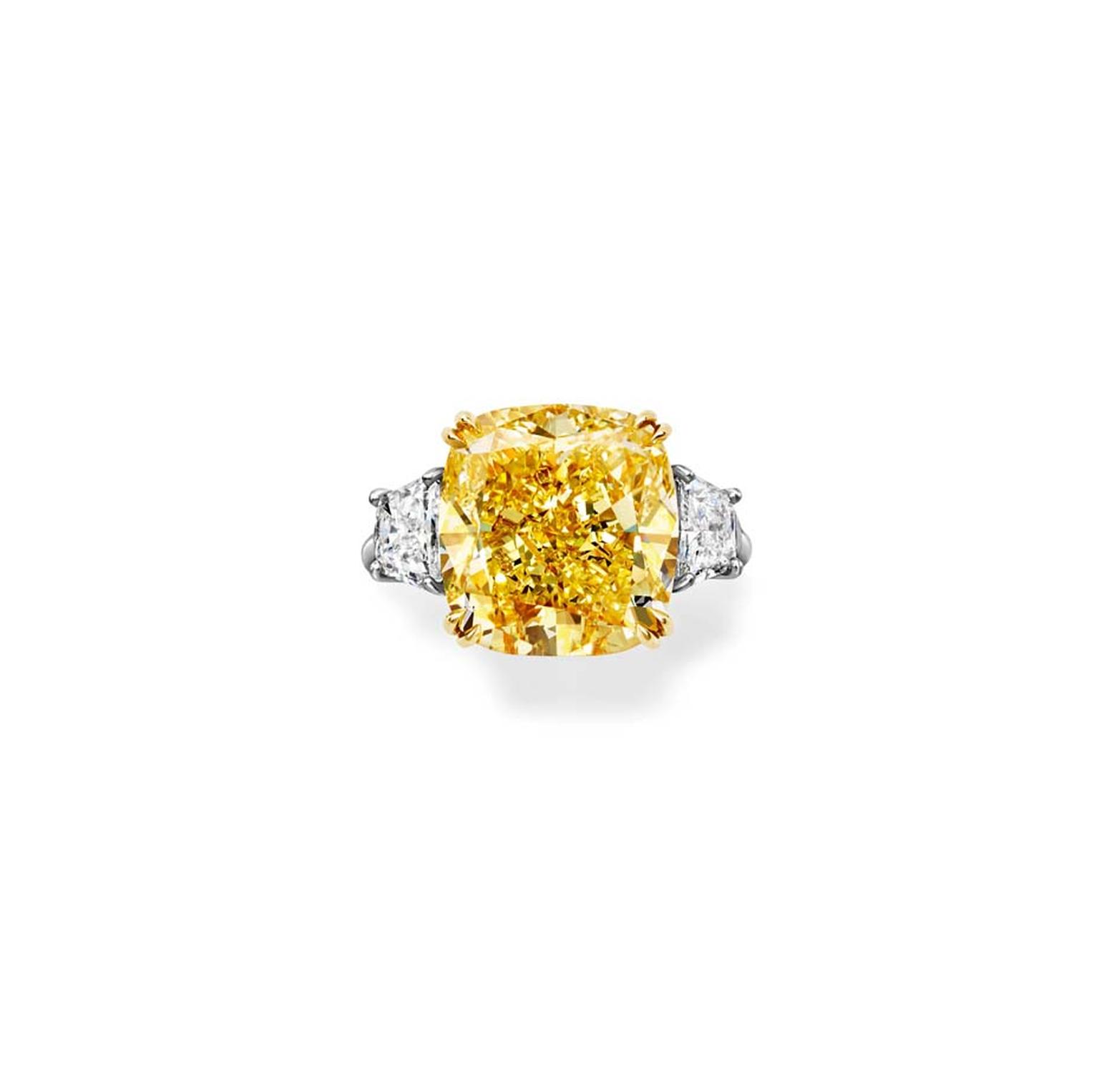 Harry Winston Classic Winston emerald-cut yellow diamond engagement ring in platinum with two brilliant-shaped diamond side stones.