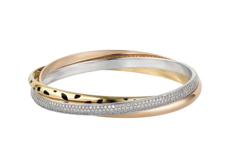 The Cartier Trinity Sauvage bracelet is a cool interpretation of the classic Trinity collection, with a white gold band pavéd with diamonds, a yellow gold band with black lacquer spots and a pink gold band engraved with Cartier.