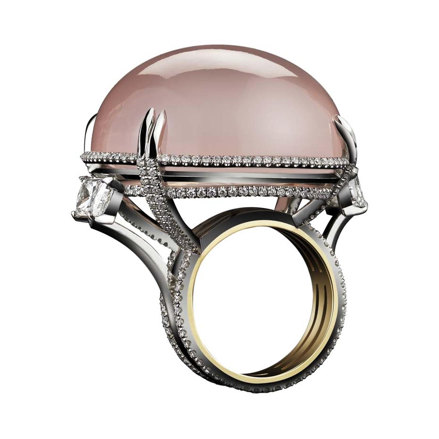 Alexandra Mor rose quartz cabochon orb ring is set slightly off-center while surrounded by pavé diamonds and two square-cut diamonds jutting out from the diamond band.