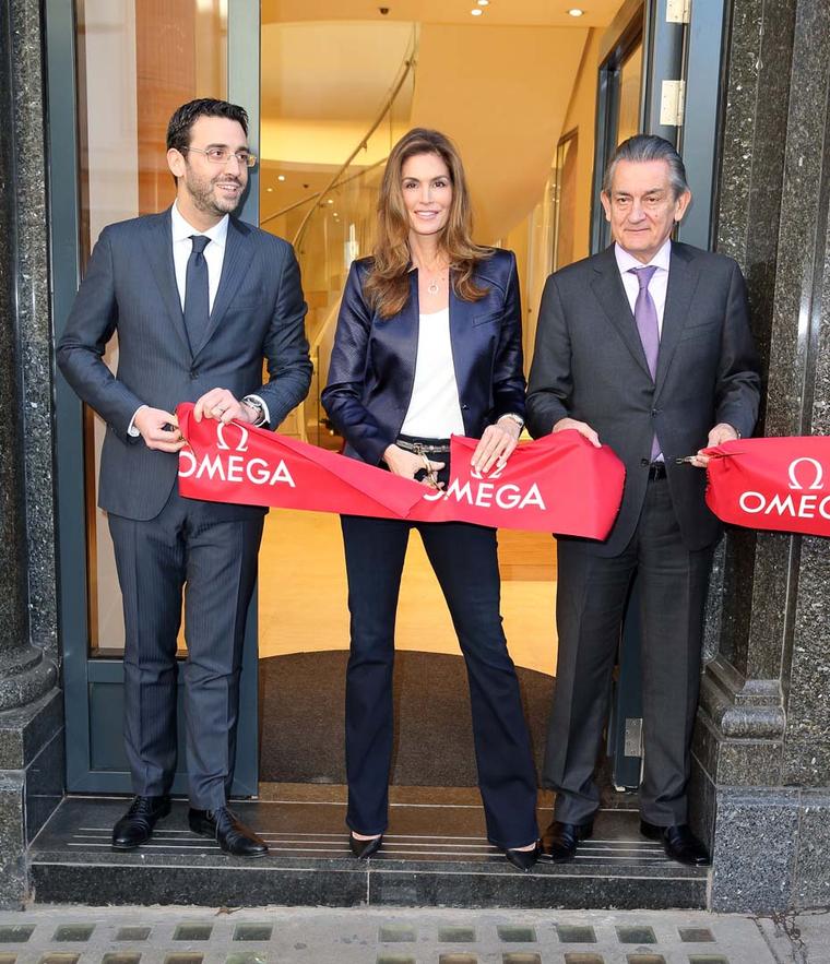 Omega ambassador Cindy Crawford cuts the traditional red ribbon alongside Omega President Stephen Urquhart, right, to officially open the brand's flagship boutique on London's Oxford Street.